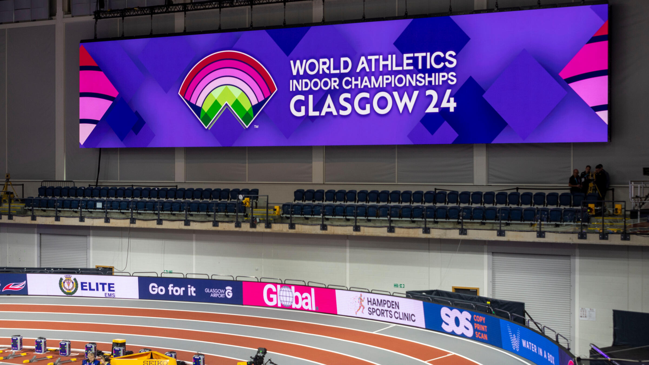 The image shows the trackside advertising of WICGlasgow24 where the SOS logo can be seen circulating the track
